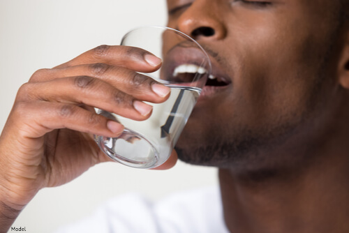 Man drinking a cup of water