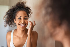 woman applying skincare products to her face