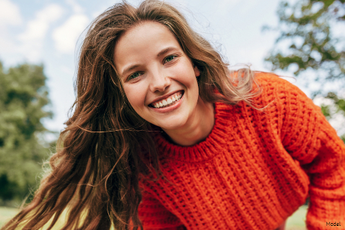 woman smiling while wearing autumn sweater