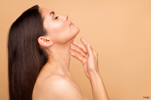 woman relaxing, feeling neck with beige background