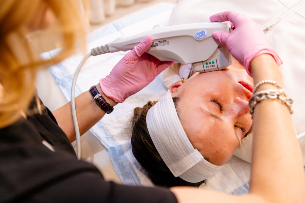 Provider places the Ultherapy in Loudoun on patient's face to contour her jawline.