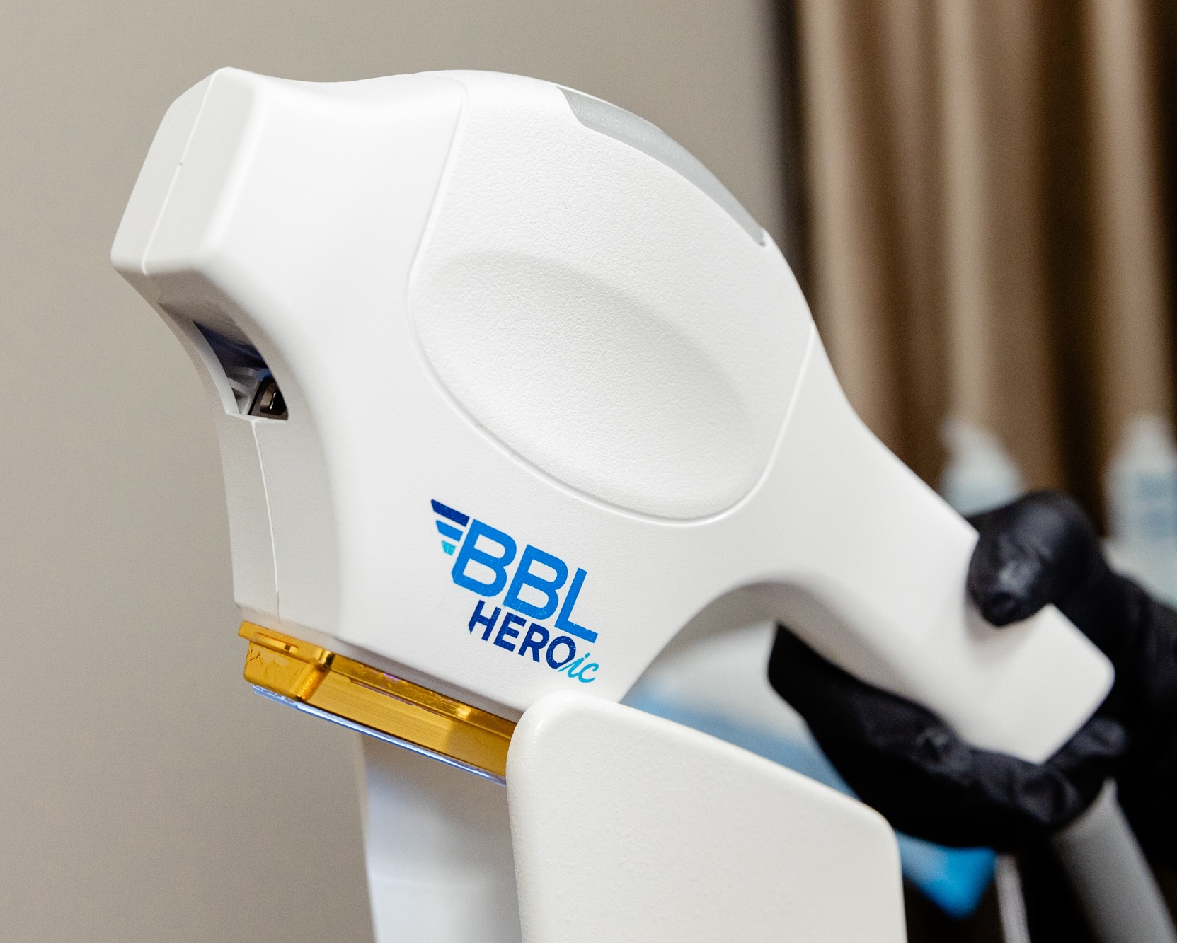 Provider wearing gloves holds the handheld treatment device for BBL HERO in Leesburg. This procedure targets pigmentation, sun damage, and uneven skin texture to improve the patient’s overall skin appearance.